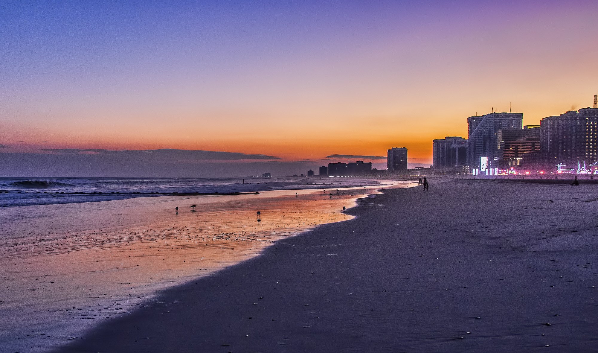 Atlantic City beach and Boardwalk skyline at sunset